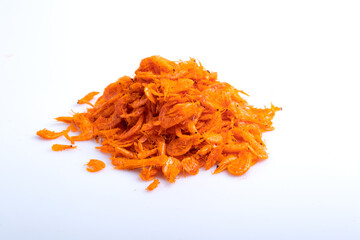 Shredded dried shrimp in a wooden cup on a white background.