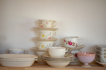Ceramic crockery and bowls arranged in a cabinet for home decoration.