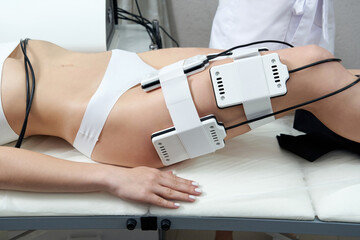 Beautiful woman getting electro stimulation therapy. Laser lipo equipment. Cosmetic fat reduce...