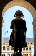 Rear view of the statue of Napoleon Bonaparte in the Hotel des Invalides in Paris, France, with french flag