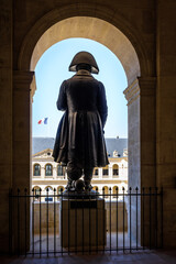 Rear view of the statue of Napoleon Bonaparte in the Hotel des Invalides in Paris, France, with french flag