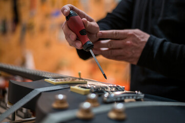 Fototapeta premium Guitar in repair service shop with a hands of a guitar luthier