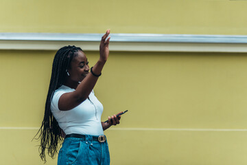 Cheerful african american woman calling for a cab