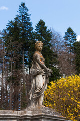 Estatua de una mujer con un fondo de arboles