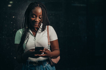 African american woman using smartphone while in a subway