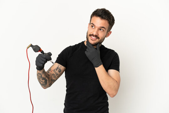 Tattoo Artist Man Over Isolated White Background Looking Up While Smiling