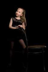 Fototapeta na wymiar Portrait of a girl who stands on a black background near the Vie