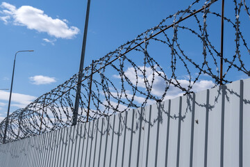 iron wall against a background of barbed wire, prison concept, rescue, refugee, lonely. Sunny day