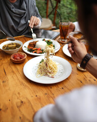BANDUNG, JAWA BARAT - 6 OCT 2018. A couple lunch together at Wange Coffe and Buffet with a different menu between traditional and western menu.