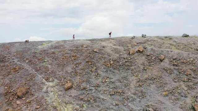 Aerial landscape of Aeolian Islands. scenic view from drone flying over volcano crater with people silhouette walking trough sulfuric smokes. Volcano Island travel destination in Sicily. Aerial pan