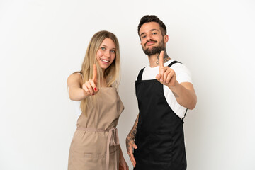 Restaurant waiter over isolated white background showing and lifting a finger