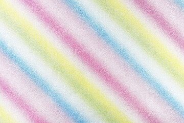 Background covered with glitter in diagonal lines in different colors of the rainbow, top view.