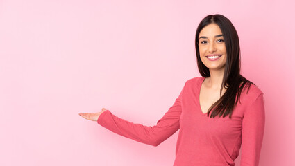Young caucasian woman over isolated background extending hands to the side for inviting to come