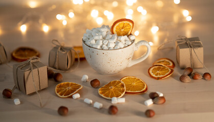 Cup of hot chocolate with marshmallows on festive background.