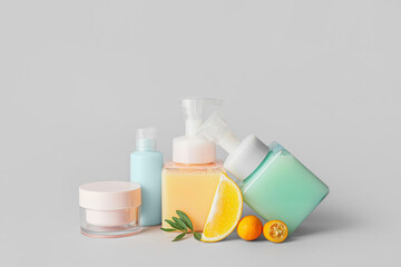 Natural cosmetic products with citrus fruits on grey background