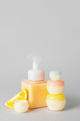 Natural cosmetic products with citrus fruit on grey background