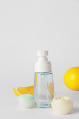 Natural cosmetic products with citrus fruit on grey background