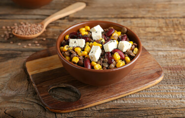 Bowl of tasty cooked lentils, beans and cheese on table