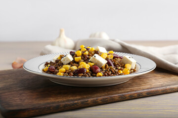 Plate with tasty cooked lentils, beans and cheese on table