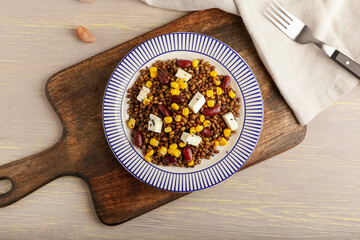 Plate with tasty cooked lentils, beans and cheese on table