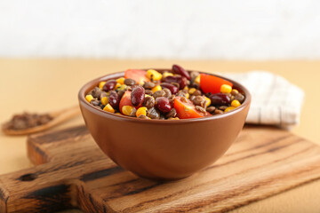 Bowl of tasty cooked lentils, beans and vegetables on table