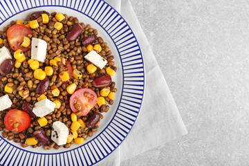 Plate with tasty cooked lentils, beans and cheese on table