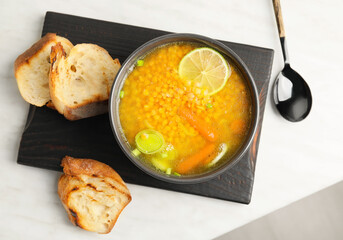 Bowl of tasty lentil soup on table