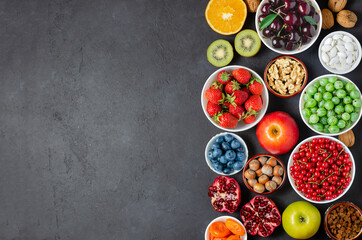 Food with a high content of antioxidants: berries, nuts, fruits. Black concrete background. Copy space