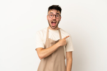 Restaurant waiter caucasian man isolated on white background surprised and pointing side