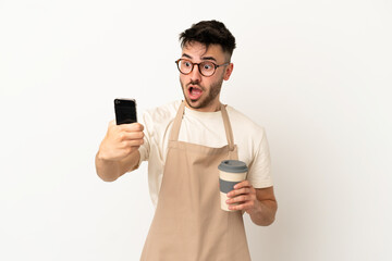 Restaurant waiter caucasian man isolated on white background holding coffee to take away and a mobile