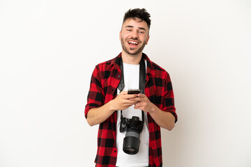 Young photographer caucasian man isolated on white background surprised and sending a message