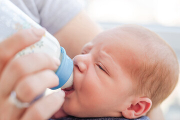 Obraz na płótnie Canvas Newborn eating from bottle