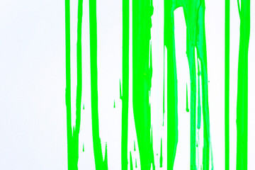 Paint streams on a  light green surface. A background with  strips from color. Vertical streams of  paint. Background abstract structure