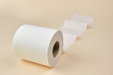 A single roll of toilet paper unrolled on a brown background