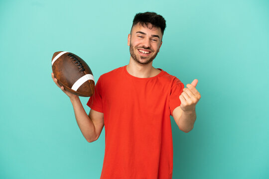 Young Caucasian man playing rugby isolated on blue background making money gesture