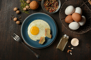 fried egg with ingredients around - dark wooden table - closeup