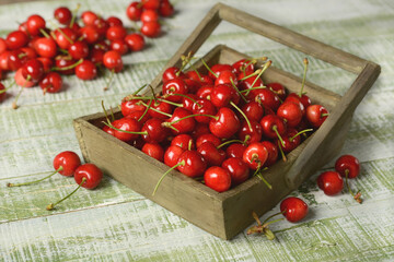 pile of organic red cherries in wooden box - closeup