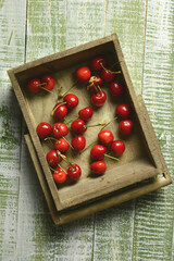 pile of organic red cherries in wooden box - closeup
