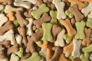 pile of dog biscuits in the shape of a bone - closeup - horizontal
