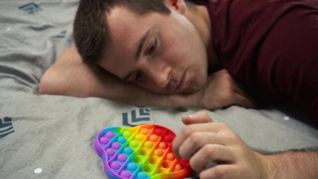 a man pokes a popular in 2021 toy pop it simple dimple