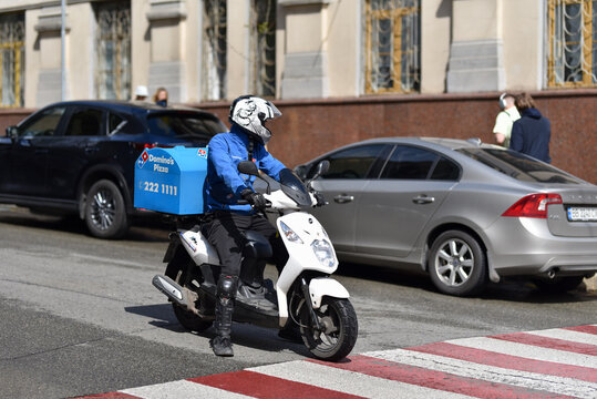 Kyiv, Ukraine - May 15 2021: Delivery man Domino's Pizza on a scooter on a city street