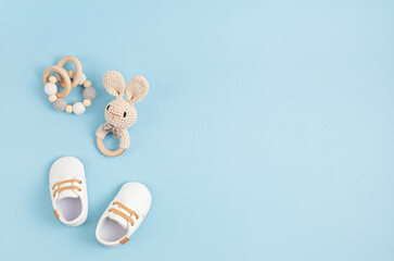 Gender neutral baby shoes and accessories over blue background