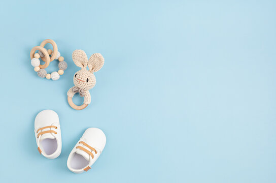 Gender Neutral Baby Shoes And Accessories Over Blue Background