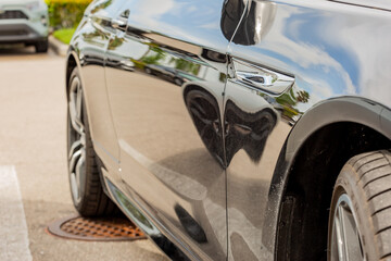 Black car side focused on the body panel