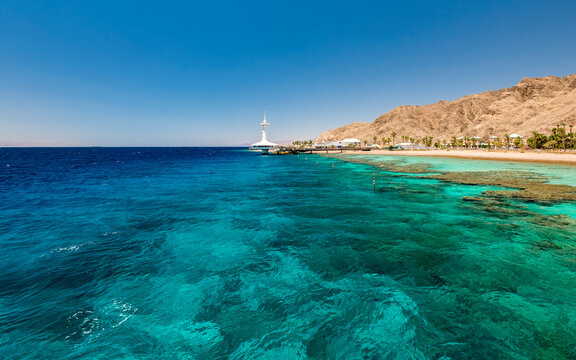 Nature with beautiful coral reefs of the Red Sea, sandy beaches, tourist hotels and mountains near Eilat, Israel, Middle East