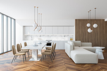 White and wooden kitchen interior with dining table and sofa