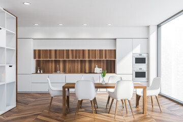 Dining table in white and wooden kitchen interior