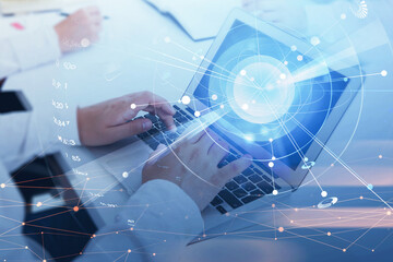 Businessman hands with laptop on office table, digital globe with network circuit