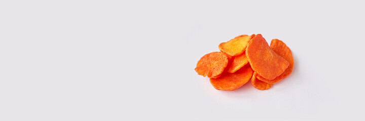 Crispy dried food. Organic tasty chips. Homemade snacks. Sliced carrot. Healthy vegetables. Orange pile Trend natural dish. Horizontal banner. Copyspace