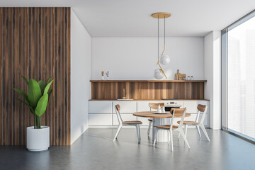 White and wooden kitchen interior with table and chairs, concrete floor